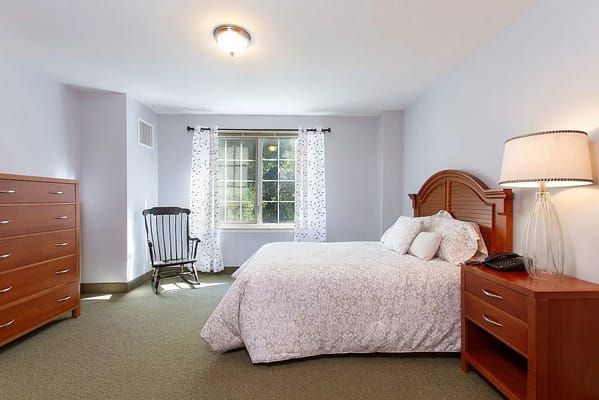 Comfortable bedroom with a bed, rocking chair, and dresser