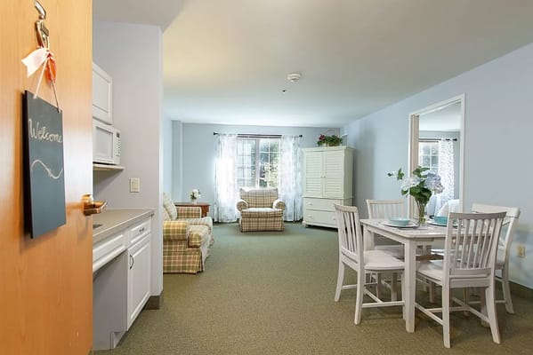 Bright living area with kitchenette and dining space in The Cascades Assisted Living