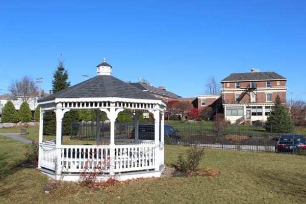 White gazebo in a landscaped area near The Chapman House.