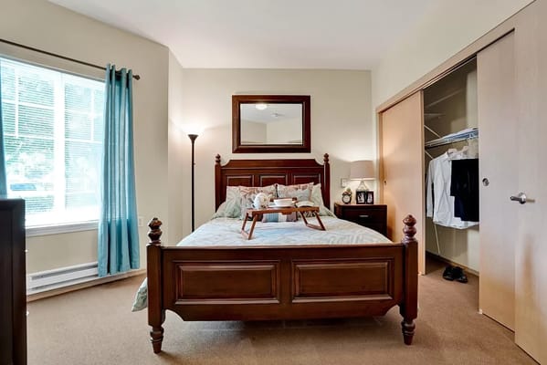 Spacious bedroom with a bed, lamp, and closet