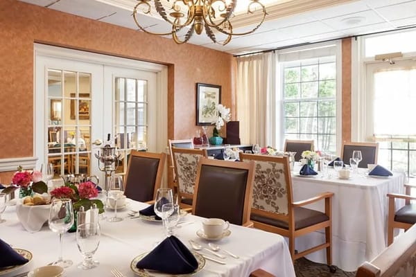 Dining room set for a meal with floral centerpieces and elegant table settings