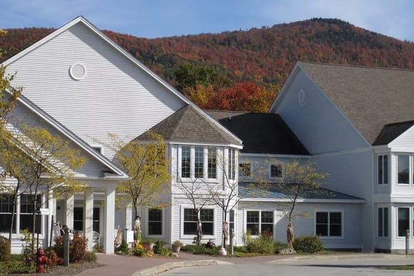 Exterior of a nursing home facility with mountains in the background