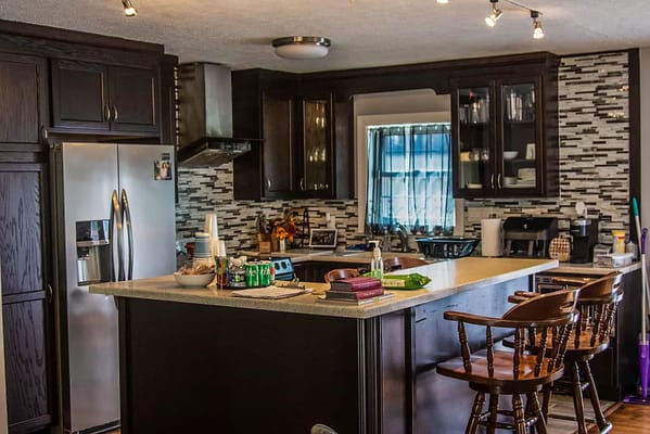 A well-equipped kitchen featuring dark cabinets and a spacious island