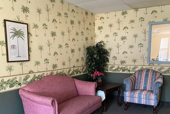 Cozy common area with comfortable seating and floral wallpaper