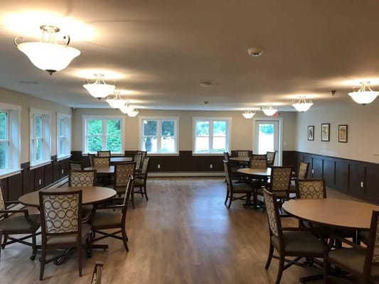 A spacious dining area with circular tables and chairs in a well-lit room
