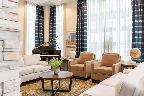 Cozy lounge area with soft seating and a piano