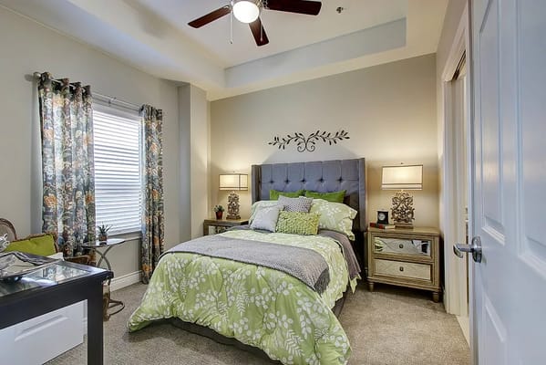 Cozy bedroom with a green and grey color scheme and floral curtains