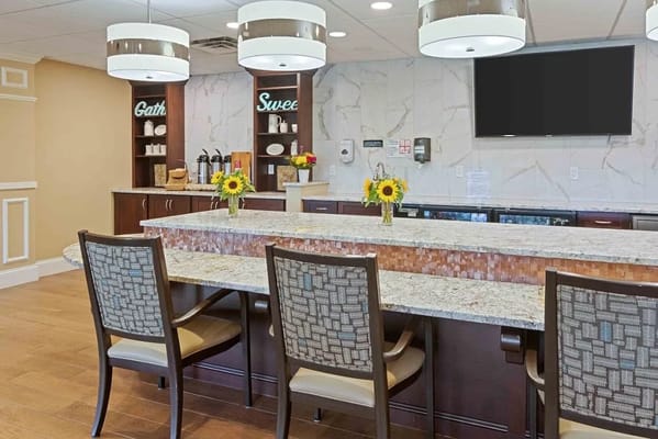 Bright common area with granite counter and flowers
