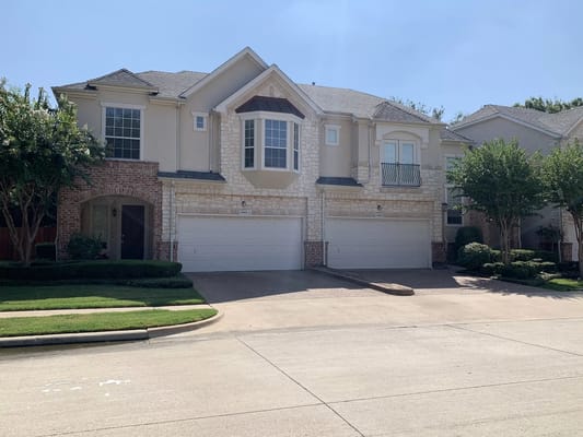 Exterior of a senior living facility with garages and landscaped entrance.