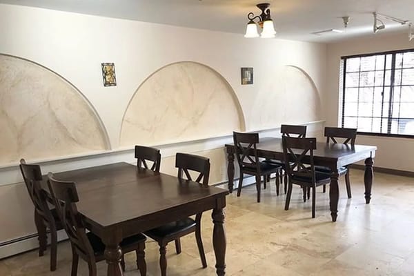 Table and chairs in a dining area with a decorative wall