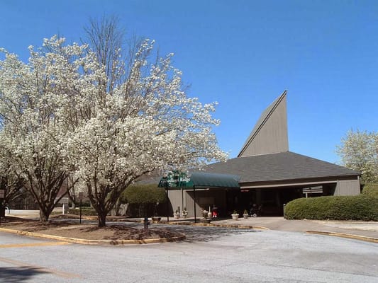 Front entrance of Woodland Ridge Assisted Living with flowering trees