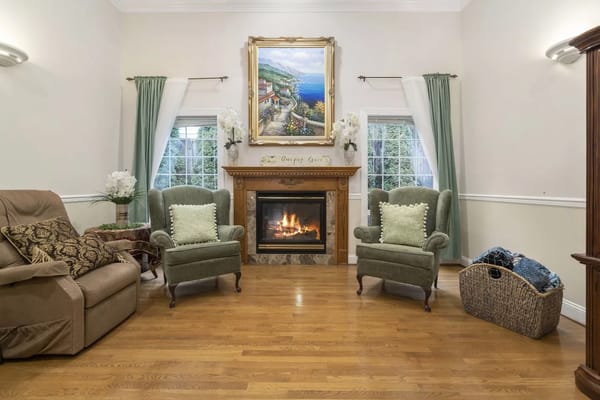 Cozy common area with green chairs and a fireplace