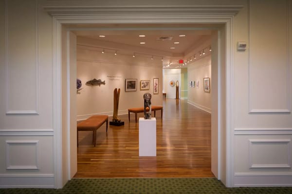 Art gallery interior with wooden flooring and sculptures