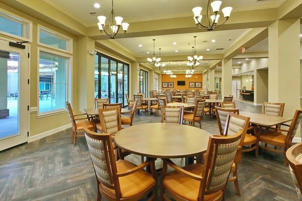 Bright dining area with tables and chairs in Vineyard Park of Surprise