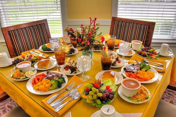 A beautifully set dining table with various meals and drinks