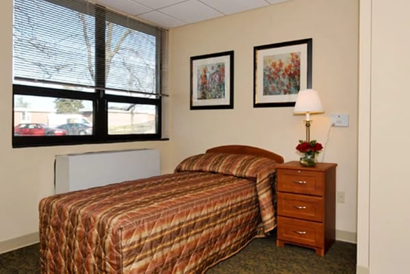 Cozy private resident room with bed and decor