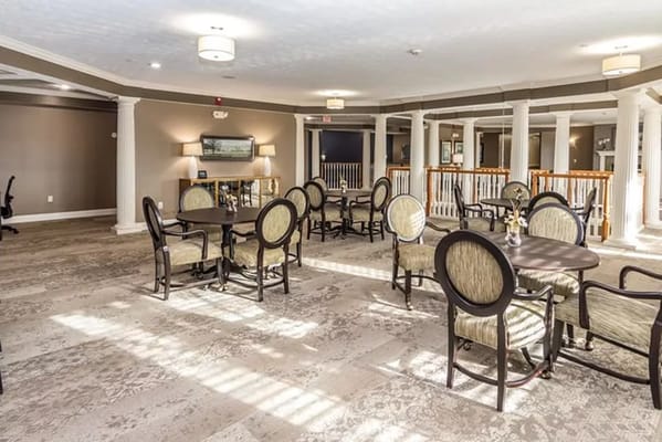 Brightly lit common area with tables and chairs