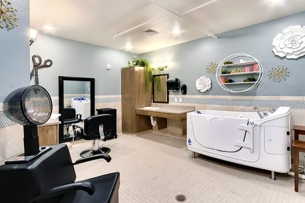 A salon and bathing area with hair styling equipment and a walk-in tub.