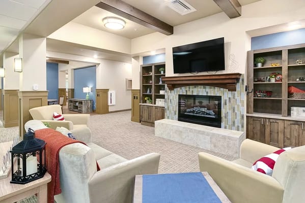 Bright and inviting common area with fireplace and seating arrangements.