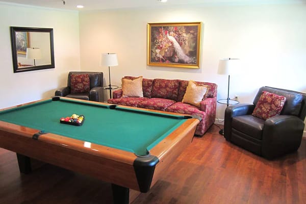 A cozy game room with a billiard table and seating