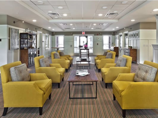 Bright common area with yellow chairs and tables