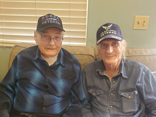 Two veterans smiling in a cozy indoor setting