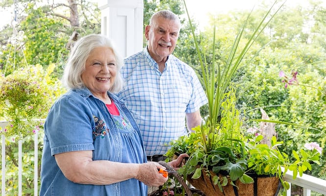 Residents happily gardening on a sunny balcony