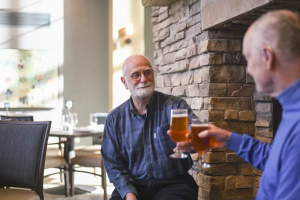Two men enjoying drinks in a dining area