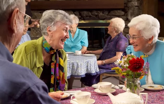 Residents enjoying tea and conversation in a cozy common area