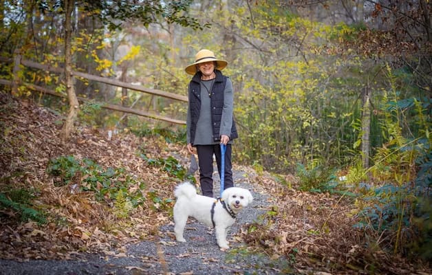 Resident walking a dog on a path surrounded by nature