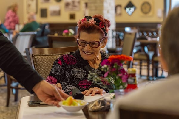 Resident enjoying a meal with flowers on the table