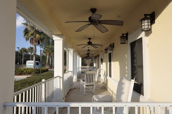 Outdoor seating area with rocking chairs and ceiling fans