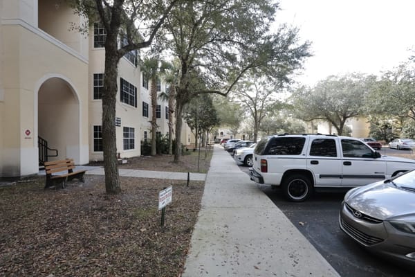 Exterior view of the facility with parked cars and a pathway
