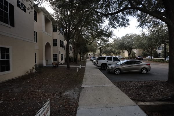 Pathway leading to the facility with parked vehicles