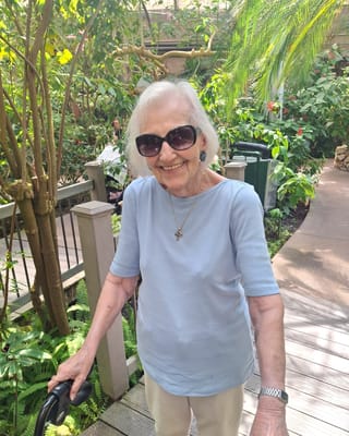 Resident smiling in a vibrant garden area