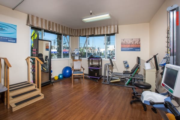 Interior of therapy room with exercise equipment and large windows
