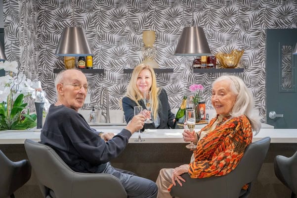 Residents enjoying drinks at the bar with staff
