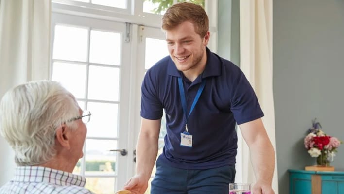Staff member serving a resident in a bright room