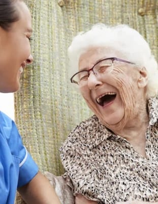 A caregiver and a resident sharing a joyful moment