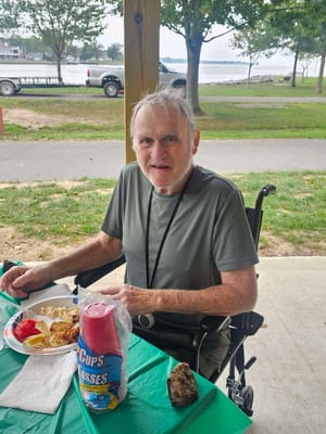 Resident enjoying a meal outdoors by the water