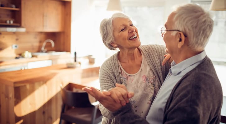 Seniors dancing joyfully in a cozy kitchen