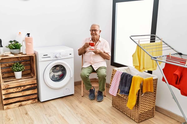 Senior man enjoying tea in a laundry room