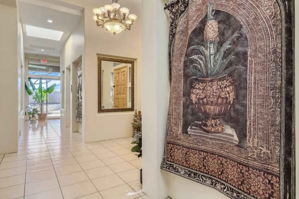 Hallway with decorative tapestry and chandelier