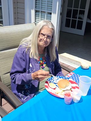 Resident enjoying a meal at an outdoor table