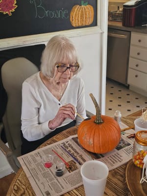 Resident painting a pumpkin at a crafting activity