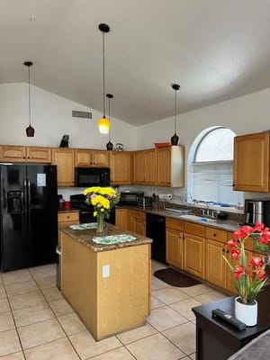 Bright kitchen area with wooden cabinets and flowers