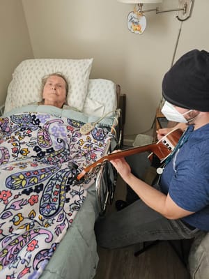Musician playing for a resident in a cozy room