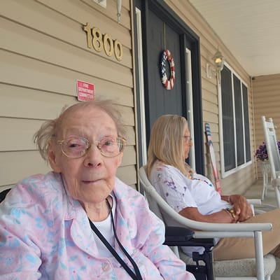 Two residents sitting outside their building
