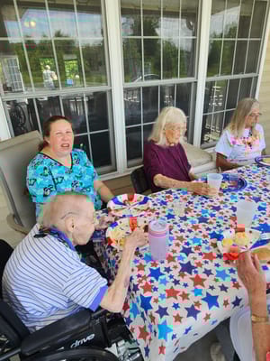 Residents enjoying a meal outside at a festive table