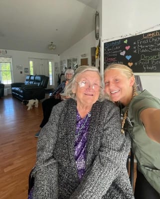 A caregiver and resident smiling together in a common area